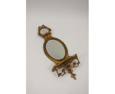 A Regency revival giltwood wall mirror with central oval plate below a circular bevelled top plate above serpentine shelves w