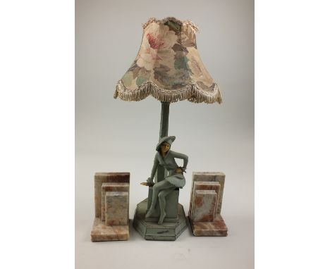 An Art Deco painted metal and composite figural table lamp, modelled as a girl seated on a pedestal with lamp post stem behin