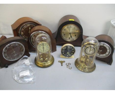 A group of oak cased Napoleon hat and other mantel clocks, a Jock alarm clock and two anniversary clocks under plastic domesL