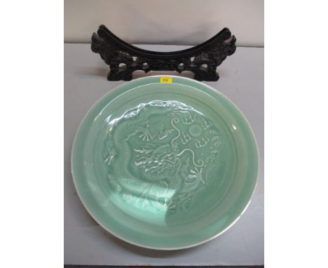 A modern Chinese celadon charger decorated with a dragon chasing a flaming pearl, with stand 