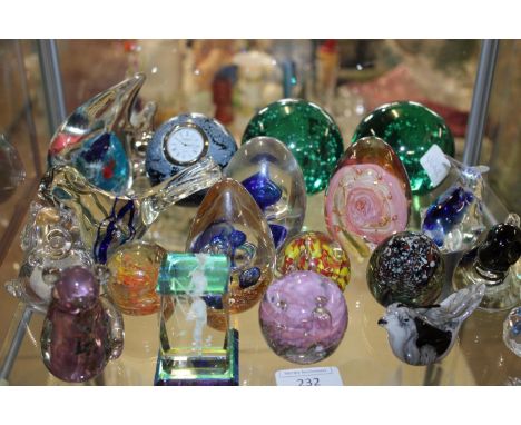 A shelf full of assorted paperweights and glass ornaments etc 