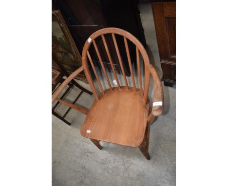 A vintage low seat carver chair having spindle back, probably Ercol, stamped 2065