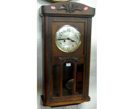 A 1930s oak drop trunk wall clock