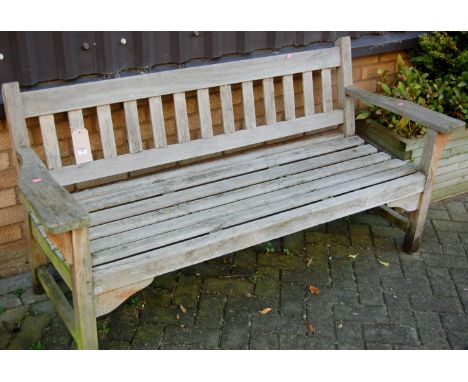 A modern slatted teak three seater garden bench 