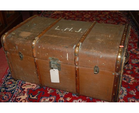 An early 20th century canvas, wooden and metal bound hinge top travelling trunk initialled L.H.J.