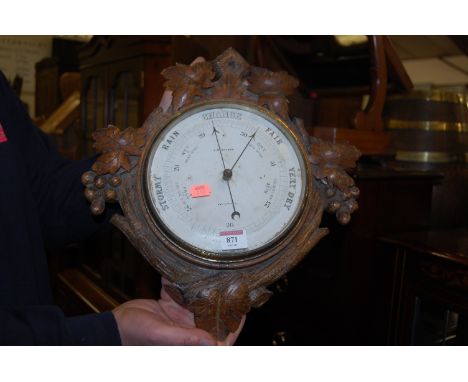 An early 20th century carved oak single dial aneroid barometer by J M Bryson of Edinburgh 