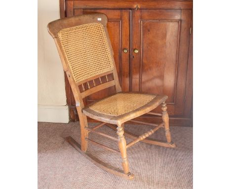 A Victorian bergere caned back rocking chair, light oak, lacking arms.&nbsp;