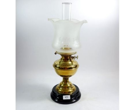 A Victorian brass oil lamp with black base and etched shade 
