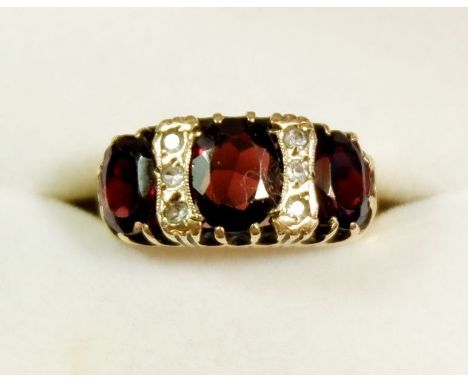 A 9ct gold ring set three garnets and six small white stones, size K-L 