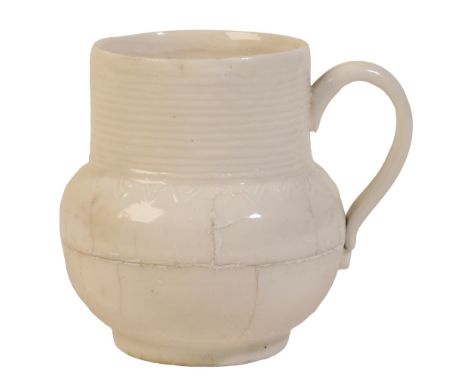 A DEHUA MUG Kangxi, with a cylindrical ribbed neck, strap handle and bulbous lower body moulded with a shoulder lappet band, 
