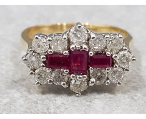 Ladies 18ct yellow gold ruby and diamond cluster ring, set with 3 baguette cut rubys in the centre surrounded by 12 round bri