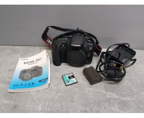A canon EOS 20D digital camera with battery, charger, memory card and manual.