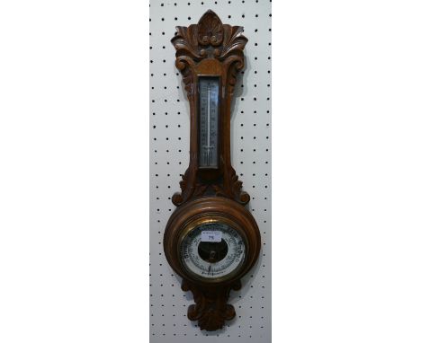 An Edwardian oak cased aneroid barometer and thermometer