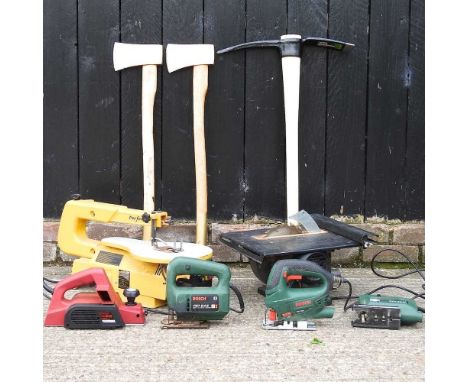 A collection of power tools, together with two axes and a pick axe
