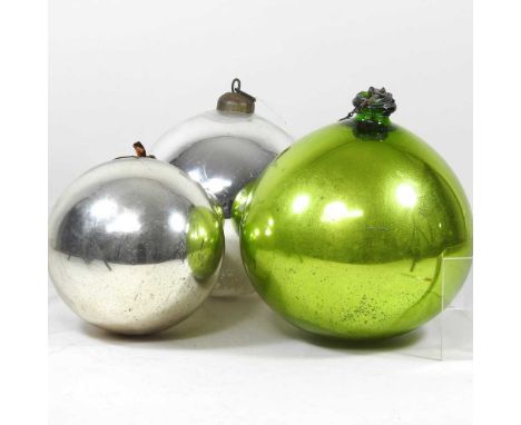 An early 20th century green glass witches ball, 23cm wide, together with two silvered glass balls (3)All are dirty, with ligh