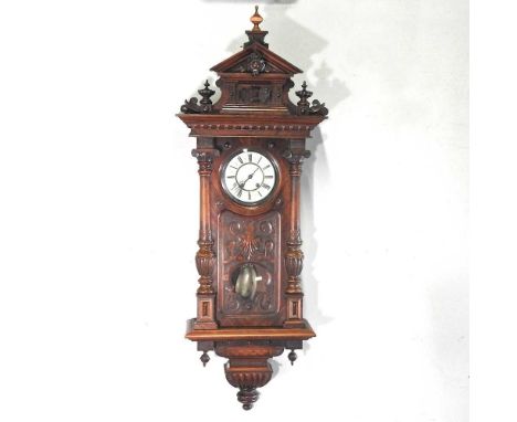 A 19th century continental carved Vienna style wall clock, with a white enamel dial and eight day movement, 150cm high