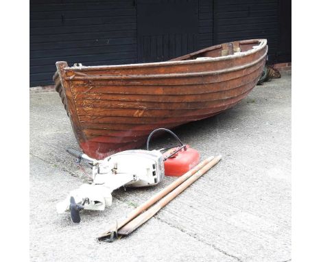 A large hand-made wooden sea-going boat, circa 1960's, together with a Johnson 6.0 outboard engine and oars. According to the