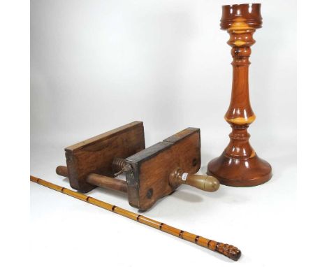 A large treen candlestick, 49cm high, together with a wooden bookbinder's plough and a bamboo swordstick (3)