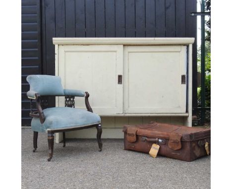 A Victorian blue upholstered armchair, together with a vintage leather suitcase and a painted cabinet, with sliding doors (3)