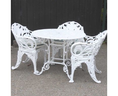 A white painted aluminium garden table, on a scrolled base, together with three cast iron garden armchairs (4)Overall conditi