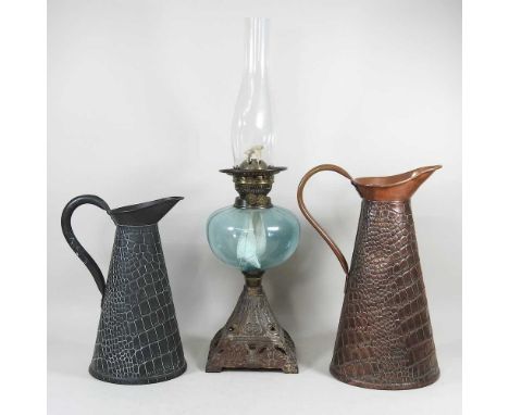 A Victorian oil lamp, with a green glass font, and chimney, 57cm high overall, together with two metal jugs (3)