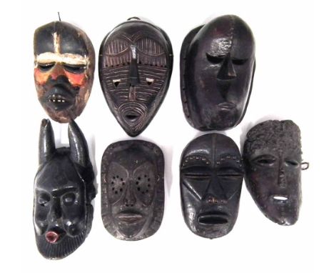 Seven African masks carved in various tribal styles, the largest measures 29cm high    All lots in this Tribal and African Ar