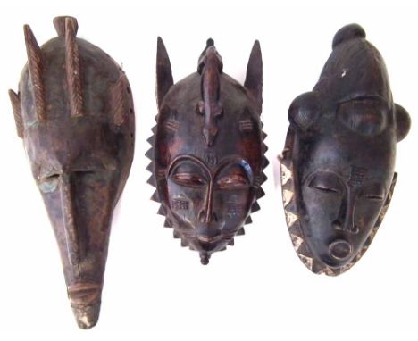 Two Guro - Yaure masks and a Warka metal mounted mask, the largest measures 41cm high     All lots in this Tribal and African