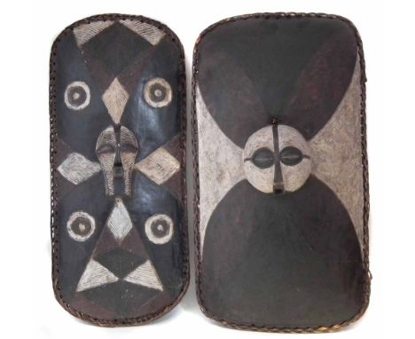 Songye shield and a similar Luba shield, both carved with masks,83cm high     All lots in this Tribal and African Art Sale ar