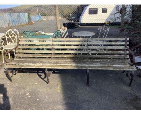 A wrought iron slatted wood garden bench, width 243cm, height 84cm. Condition - poor