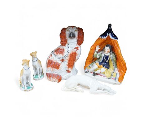 Four Victorian Staffordshire models, to include a pair of dogs, and a Nymphenburg whippet, largest 25cm high. Condition - fai