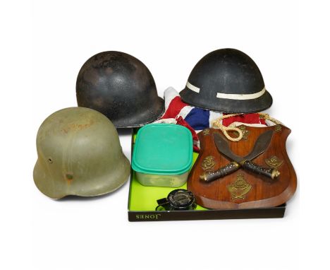 A collection of military items, including a U.S. Army helmet, an M42 helmet, a WWII British Home Front helmet, a Union flag 9