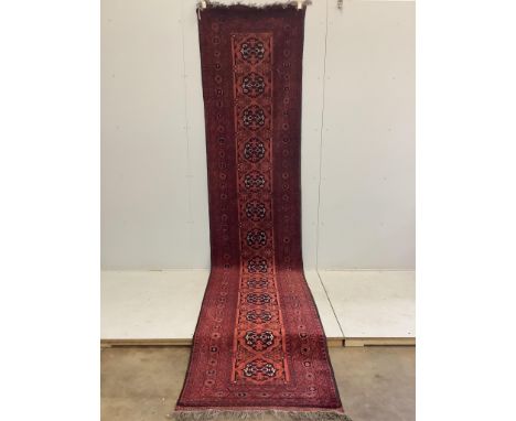 An Afghan red ground runner, approximately 400 x 86cm. Condition - fair