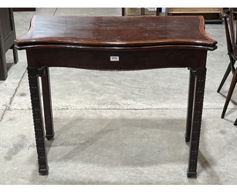 A 19th century mahogany and crossbanded serpentine card table with small drawer to the back panel, raised on blind fret carve