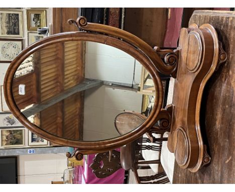 A Victorian mahogany dressing table mirror, the oval plate over a concave base with a pair of trinket boxes. 24" wide.