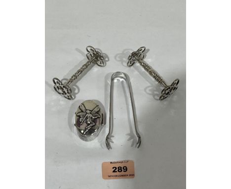 A silver pill box; a pair of white metal knife rests and a white metal sugar bow