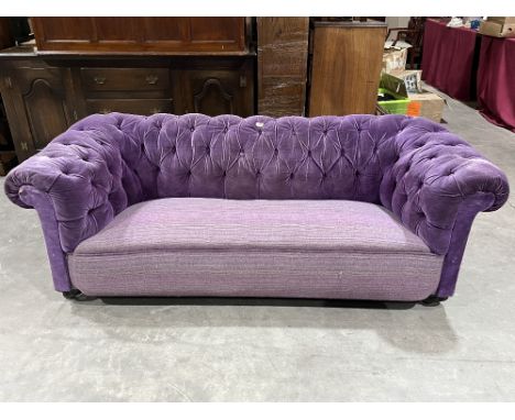 A Victorian chesterfield sofa upholstered in deep buttoned velvet. 72" long.