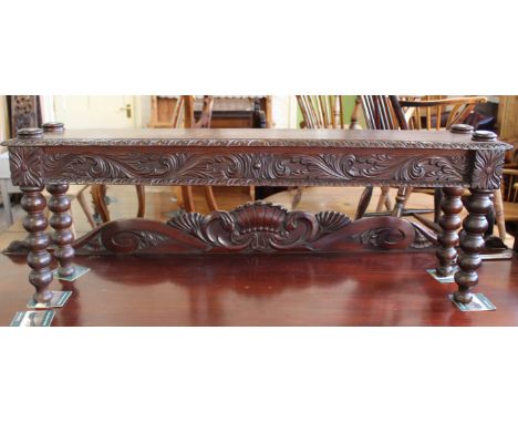 A late 19th Century carved oak hall seat on bobbin turned legs
