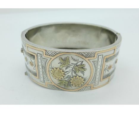 A silver and gold applied bangle, width 26mm