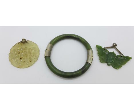 A bangle, a silver mounted jade pendant and a carved circular pendant