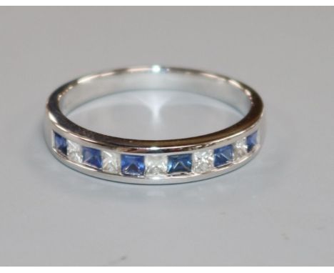 A modern 18ct white gold, eleven stone sapphire and diamond half eternity ring, size R.