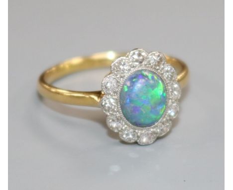 An 18ct gold and platinum, black opal and diamond cluster oval ring, size L.