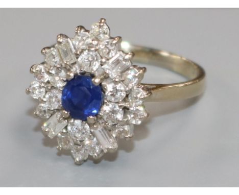 An 18ct white gold, sapphire and diamond cluster dress ring, set with baguette and round cut diamonds, size T