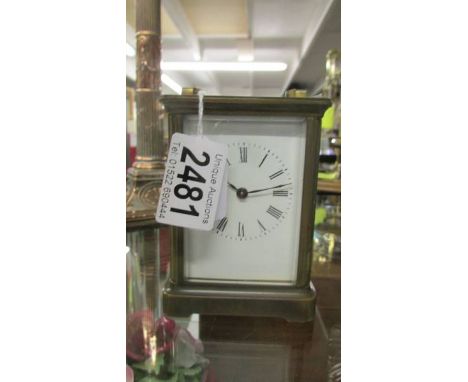 A brass carriage clock with key.