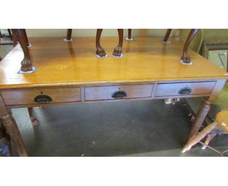 A light oak three drawer library table.