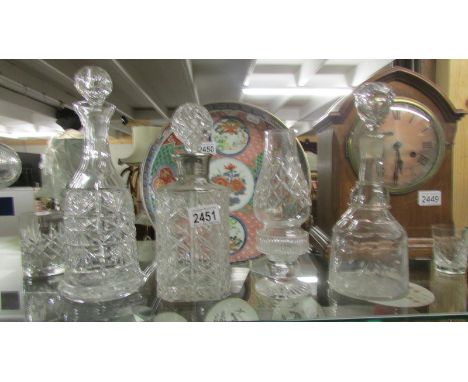 Three cut glass decanters and a glass candle lamp.