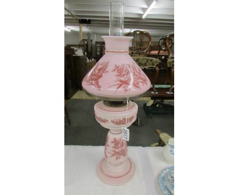 A nice quality pink glass oil lamp hand decorated with birds.