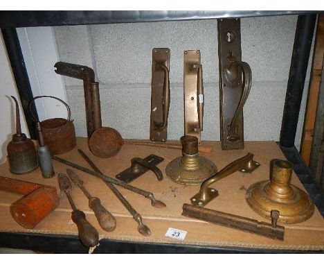 A shelf of assorted brass door handles and other architectural items.