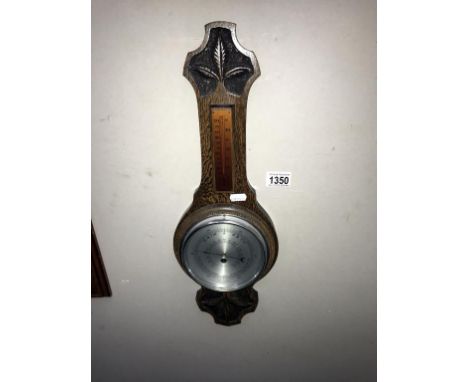 An Edwardian carved oak barometer (length 51cm)