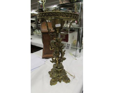 A Victorian solid brass cherub table lamp base (needs re-wiring).