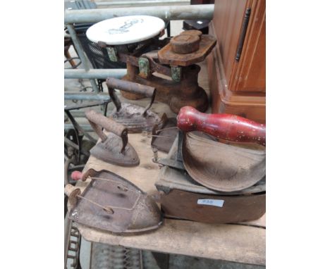 A selection of vintage flat irons and a kitchen scale